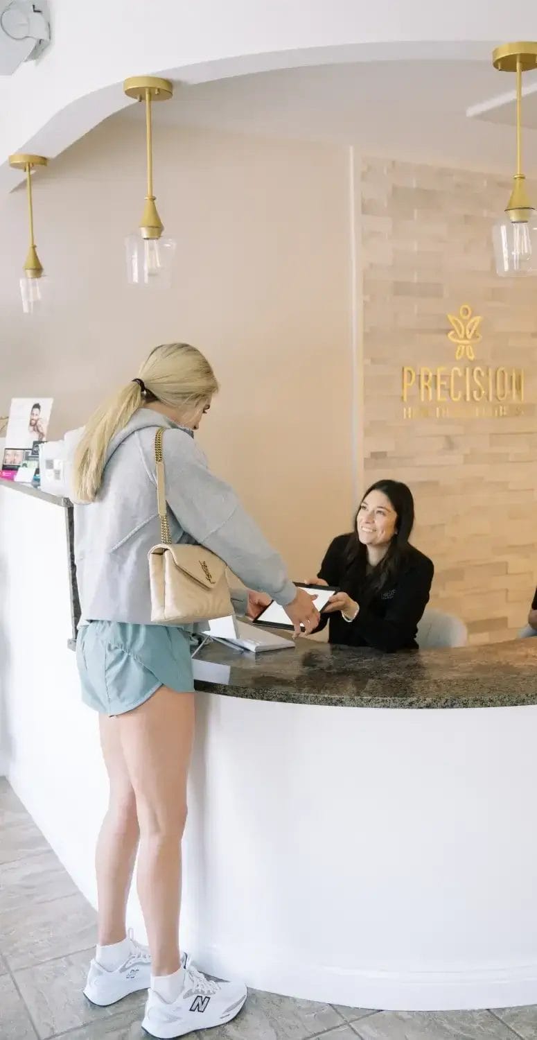 Reception area at Precision Health and Wellness with staff assisting a client